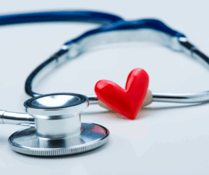 Close-up of a stethoscope with a small red heart, representing patient care and the protection of sensitive medical data.