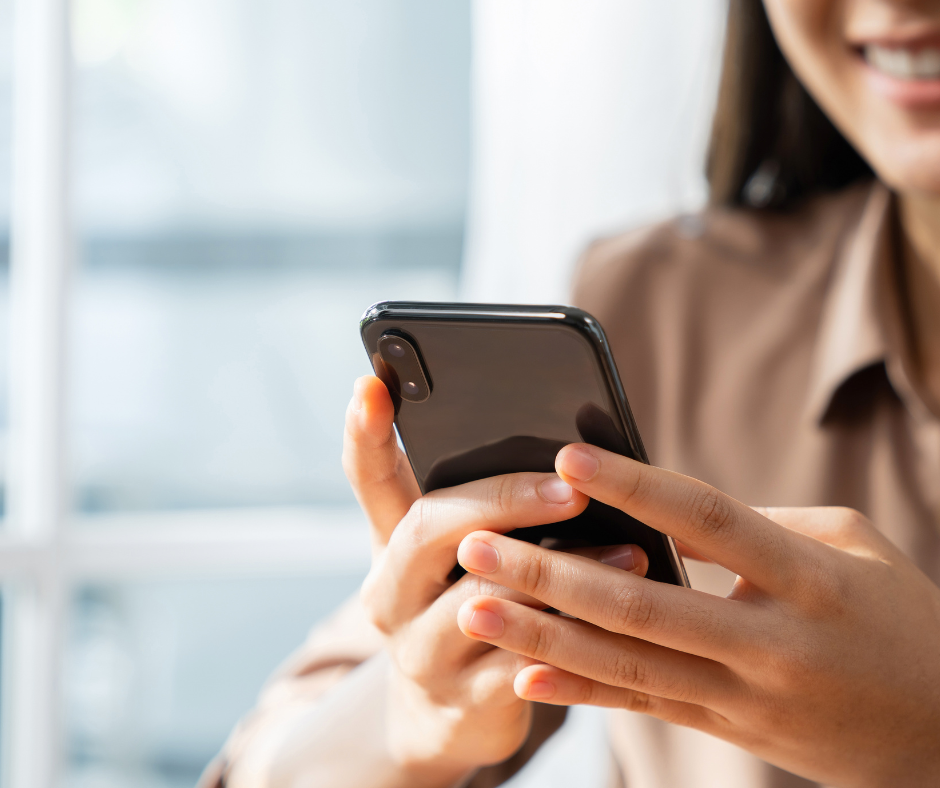 A woman checking her phone for an MFA code, showing one of the many protocols in Digital Identity and Verification for Remote Workers