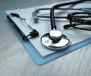 A stethoscope on a clipboard, showing the significance of IAM in patient data protection