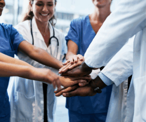 Doctors and hospital staff connecting their hands, symbolizing the security and protection provided by Healthcare IAM solutions