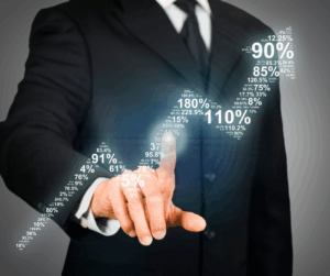 Businessperson in a suit pointing at an upward path of floating percentage values, symbolizing performance growth and improvement tracking.