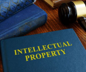 Book titled 'Intellectual Property' on a wooden desk with a gavel and other law books, symbolizing IP protection.