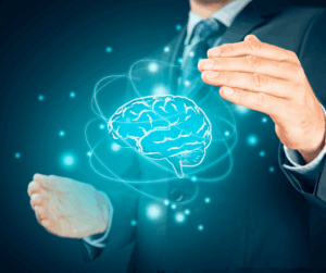 Businessman’s hands surrounding a glowing holographic brain, representing the protection of intellectual assets.